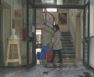 Una bidella impegnata ad asciugare lingresso dellistituto 