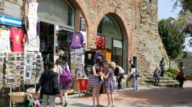 In senso antiorario: l’ingresso del nuovo Museo Leonardiano, il mulino più vicino alla casa natale di Leonardo, e poi una sala interna al Museo e alcuni turisti a passeggio nel borgo storico di Vinci
