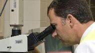 Ricercatore al microscopio nel suo laboratorio
