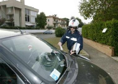 Un vigile che multa unauto per la pulizia strade 