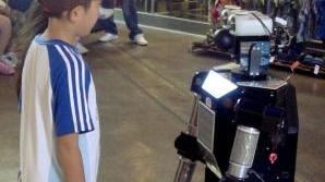 Un bambino davanti a un robot: aumentano le insidie che arrivano all’infanzia dalle nuove tecnologie