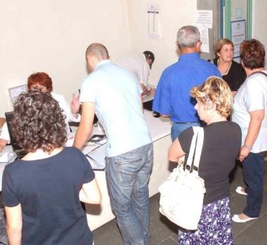 Cittadini in fila in un ufficio 