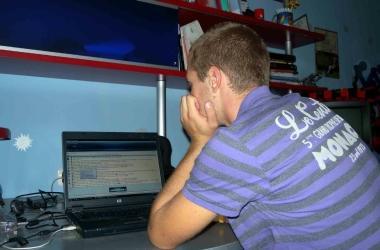Un adolescente davanti al suo pc mentre chatta con degli amici virtuali (foto darchivio) 