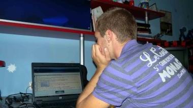 Un adolescente davanti al suo pc mentre chatta con degli amici virtuali (foto d’archivio)
