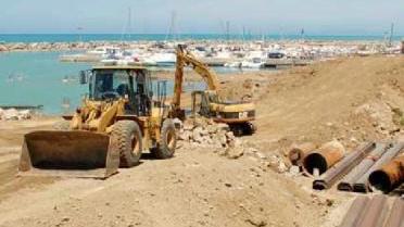 La spiaggia affollata e i lavori al porto