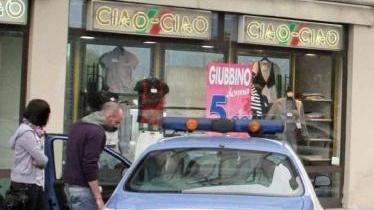 Luca Pretazzini parla con gli agenti davanti al negozio che vendeva le magliette con il volto di Mussolini