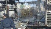 Un poliziotto sul posto dell’incendio fra carcasse di auto bruciate