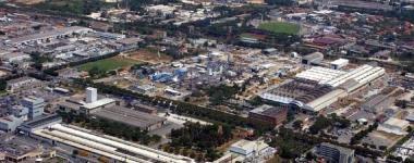 Una veduta della zona industriale di Massa e sotto un corteo dei lavoratori 