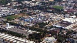 Una veduta della zona industriale di Massa e sotto un corteo dei lavoratori