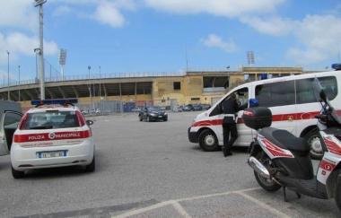 I vigili urbani mentre liberano il parcheggio del campo scuola e uno dei cartelli di divieto di sosta 
