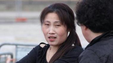La donna cinese rapinata si tampona un braccio