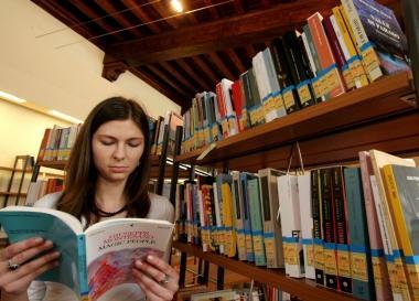 Consultazione di libri in una biblioteca       