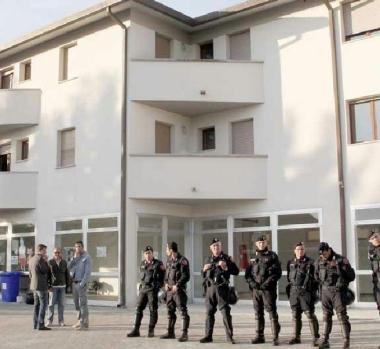 Una mamma costretta a cambiare i pannolini al bimbo in strada dopo lo sgombero. A sinistra in basso il presidio in Largo Menotti