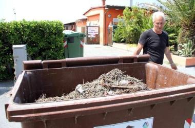I bidoni pieni della sporcizia raccolta sulla spiaggia 