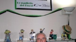 Dino Bencini davanti alle statuette dei “Buzzini” in mostra alla parrocchia del Sacro Cuore