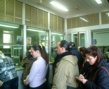 Utenti in fila davanti a uno sportello postale