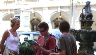 A sinistra, turisti in visita a Prato in piazza del Comune. Sopra, una nave da crociera 