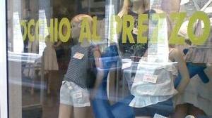 Una vetrina su cui campeggia l’avviso dei saldi