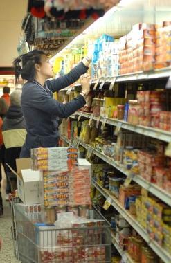 Un’addetta al rifornimento scaffali in un supermercato