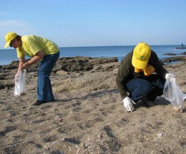 Due volontarie raccolgono cicche su una spiaggia 