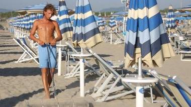 <b>SPIAGGIA «CHIUSA» TROPPO PRESTO.</b> Bagnini al lavoro fra gli ombrelloni Sopra: il vicesindaco Costagliola sul molo