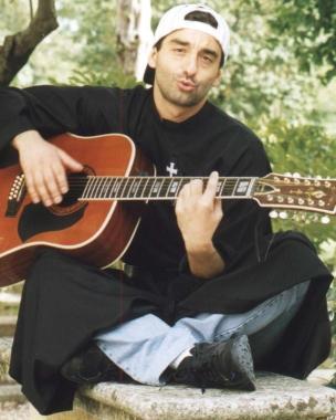 Padre Nike alla chitarra e, a destra, insieme a Fiorello, uno degli artisti con cui ha cantato