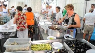 Preparazione del pesce per la Sagra e le persone a cena in piazza Bovio