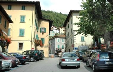 Auto parcheggiate a Cutigliano. A destra, turisti a passeggio 