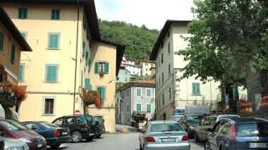 Auto parcheggiate a Cutigliano. A destra, turisti a passeggio
