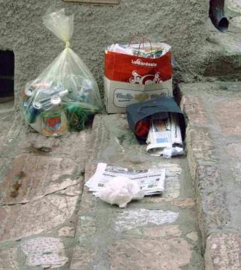 Sopra il sindaco Roberto Peria, accanto sacchetti di differenziata abbandonati in strada 
