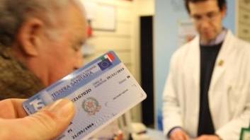 Un cliente esibisce la tessera sanitaria in farmacia (foto archivio)