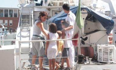 Una mamma con i figli sale a bordo di una motovedetta della Capitaneria 