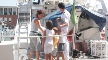 Una mamma con i figli sale a bordo di una motovedetta della Capitaneria