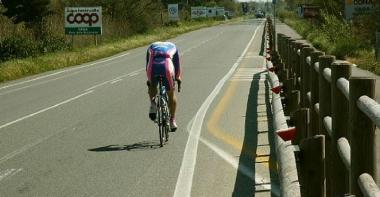 Un ciclista viaggia tranquillo sull’Aurelia mentre a fianco c’è la pista ciclabile