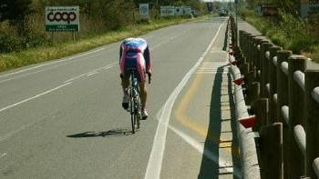 Un ciclista viaggia tranquillo sull’Aurelia mentre a fianco c’è la pista ciclabile