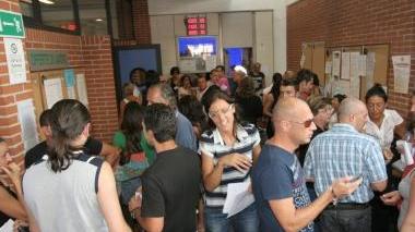 Giovani in fila davanti alla bacheca di offerte della Fil