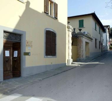 La sede della polizia municipale di Cerreto e più a destra erba alta ai margini di una strada