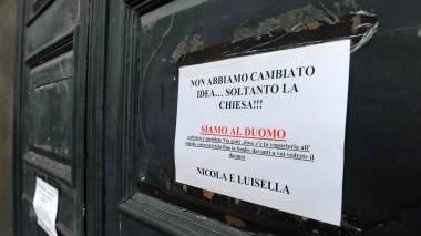 Il cartello che gli sposi hanno affisso alla porta della chiesa del Crocifisso e Nicola e Luisella dopo la cerimonia in Duomo
