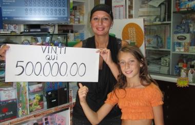 Francesca Calvelli, la tabaccaia di via Bixio, mostra esultante il cartello che indica la vincita 