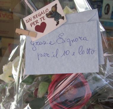 Il biglietto sul mazzo di rose inviato alla tabaccaia Francesca Calvelli (a destra insieme alla figlia Ginevra) 
