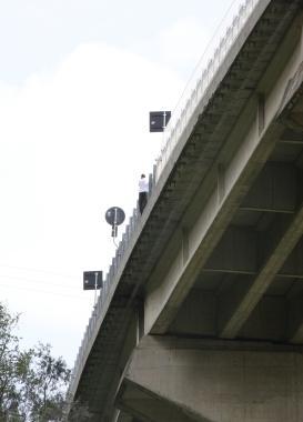 A sinistra luomo mentre si sporge nel vuoto, qui sopra il momento in cui viene salvato da soccorritori Sotto le auto in coda sulla bretella e a destra laltezza del viadotto 
