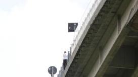 A sinistra l’uomo mentre si sporge nel vuoto, qui sopra il momento in cui viene salvato da soccorritori Sotto le auto in coda sulla bretella e a destra l’altezza del viadotto