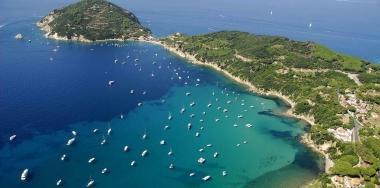 Sopra il sindaco di Portoferraio, Roberto Peria, accanto una panoramica del golfo di Viticcio affollato di imbarcazioni da diporto. Il Comune propone la realizzazione di un campo boe con il Parco 