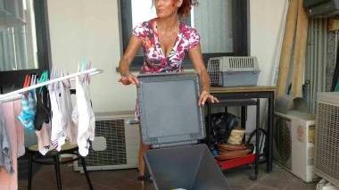 Una signora mostra un bidoncino per la raccolta differenziata porta a porta