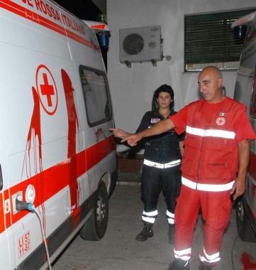 Un volontario mostra lambulanza imbrattata di vernice rossa; a destra un carabiniere fotografa la scritta che accusa la Croce rossa per un episodio accaduto sabato scorso in un centro despulsione a Milano 
