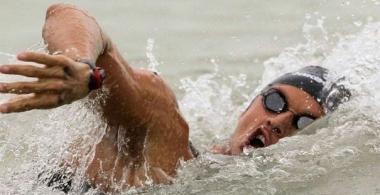 A sinistra Simone Ercoli durante una delle sue faticose imprese consumate in acque aperte e, qui sopra, il pluri-decorato atleta di Castelfiorentino sul podio europeo della staffetta (ultimo a destra) insieme ai compagni di nazionale Simone Ruffini e Rachele Bruni 