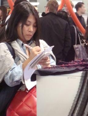 Una cliente prende appunti sui campionari delle aziende pratesi   