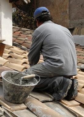 Un muratore allopera su una tettoia     