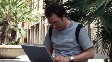 Un giovane mentre naviga sul proprio pc portatile