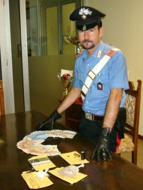 Un carabiniere mostra la droga ed i soldi sequestrati dai militari nella casa di via Giordano Bruno                  